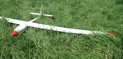 white foam glider with red wing tips on grass
